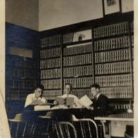 Three men at a table in McMahon Library